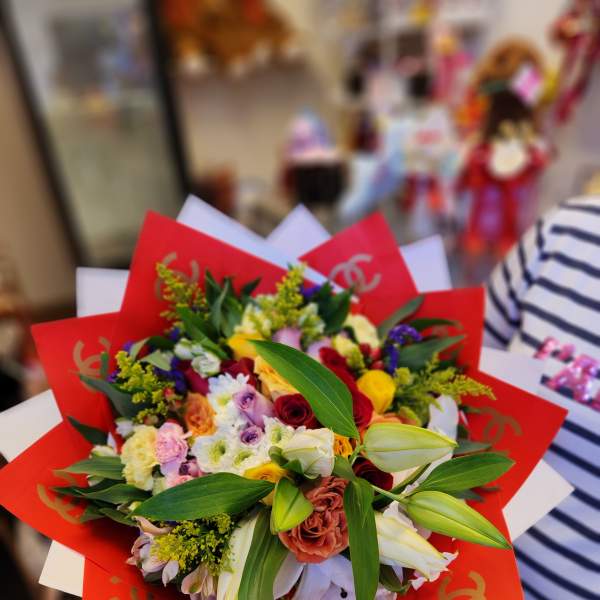 Mixed bouquet with red wrapping and white lilies