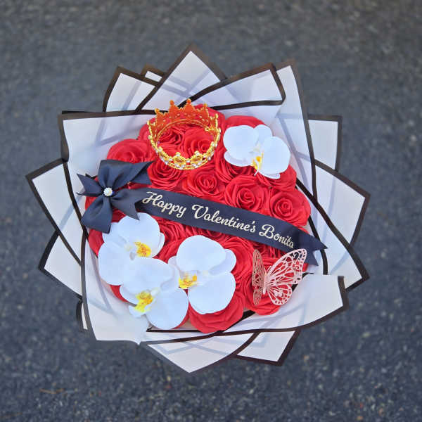 Red rose bouquet with white orchids, a crown, and a Valentine ribbon