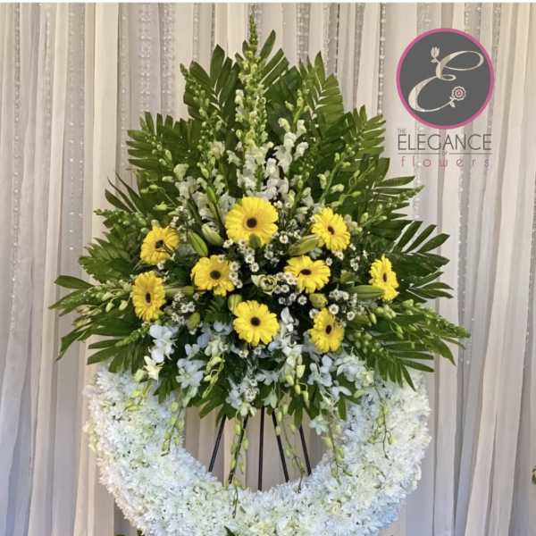Large standing floral tribute with yellow and white flowers on an easel