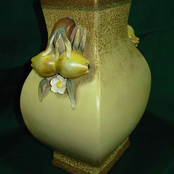 Decorative ceramic vase with yellow fruit and a small white flower