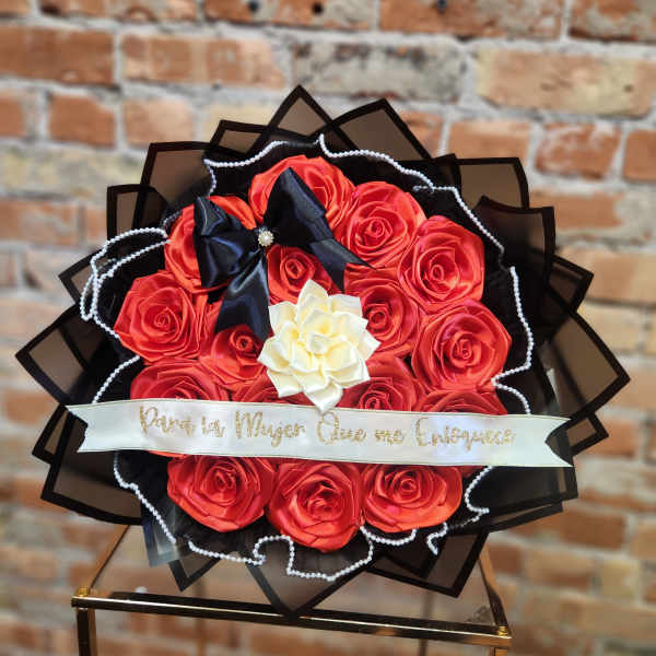Bouquet of red roses with a white flower center and black ribbon