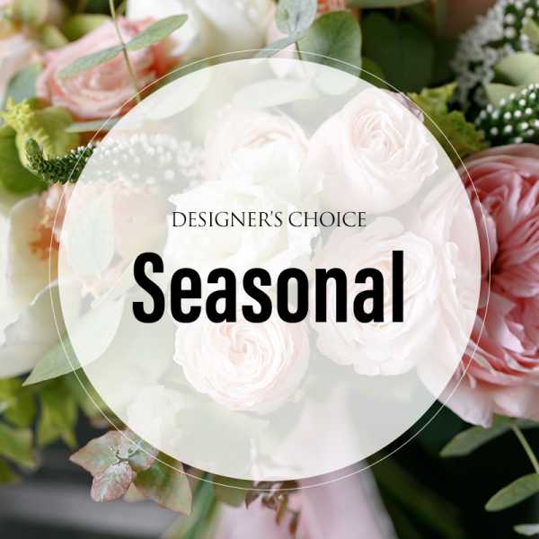 Soft pink and white roses in a floral arrangement with greenery