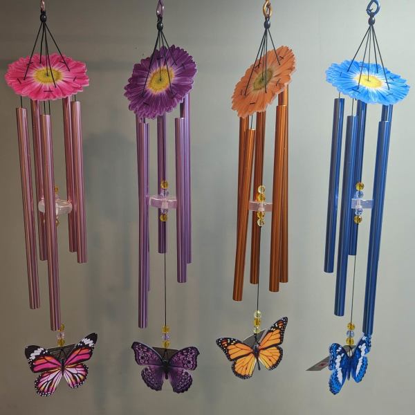 Four hanging wind chimes with daisy tops and butterfly ornaments.