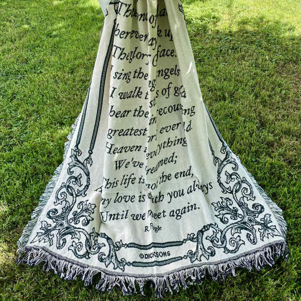 Memorial blanket draped outdoors with a large white bow