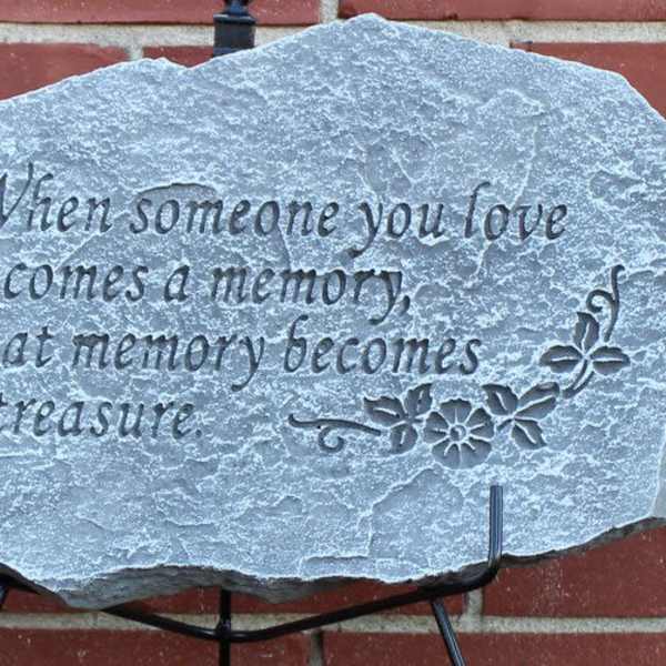 Engraved memorial stone with a quote on a brick wall