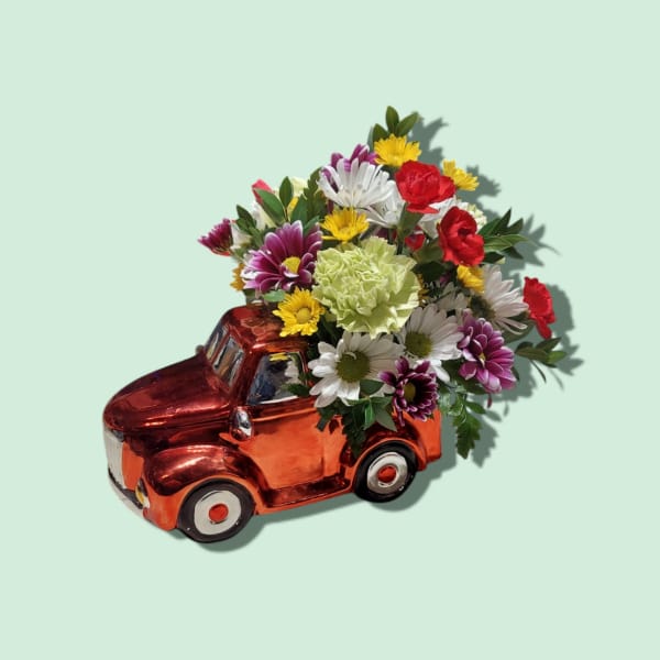 Flower arrangement in a red ceramic truck-shaped container