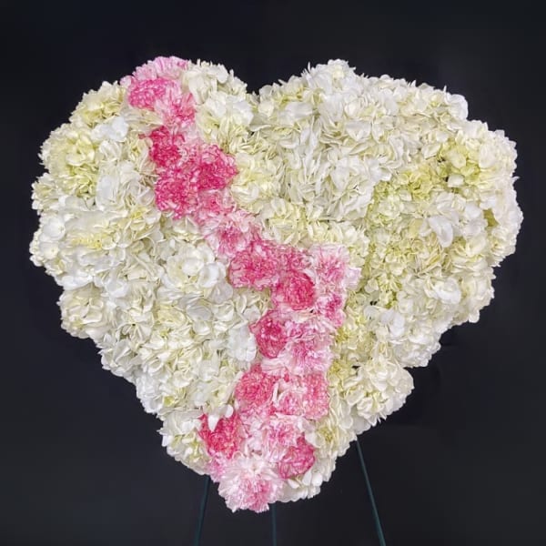 Heart-shaped floral arrangement of white and pink carnations