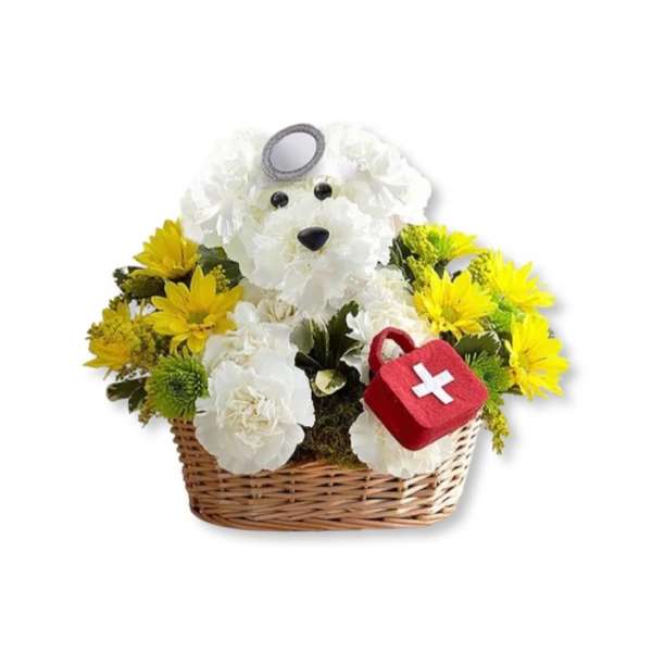 White teddy bear arrangement in a wicker basket with yellow flowers and a red first-aid bag