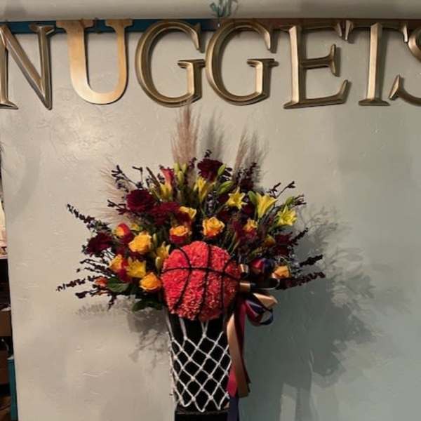Basketball-themed floral arrangement in a black pedestal vase