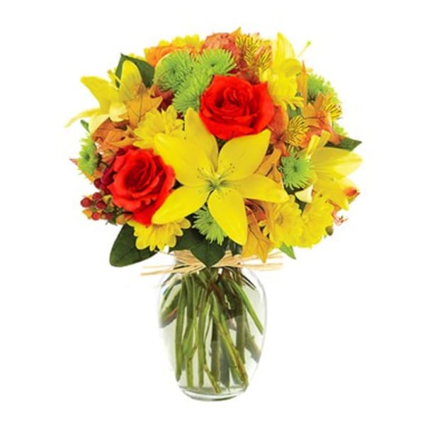 Bouquet of red roses and yellow lilies in a clear glass vase