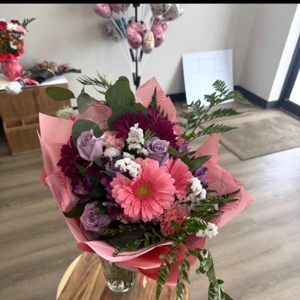 Pink and lavender bouquet in a glass vase with mixed blooms