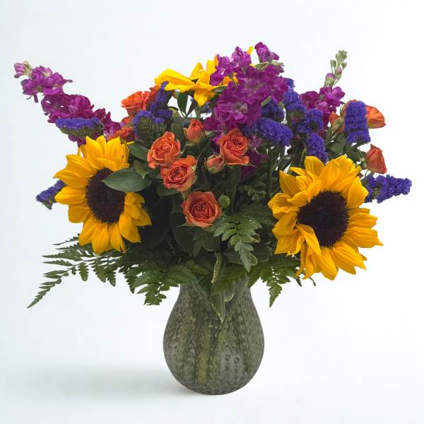 Bouquet of sunflowers, orange roses, and purple flowers in a green vase
