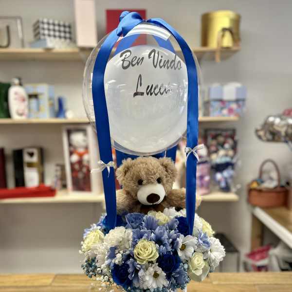 Balloon arrangement with a teddy bear and blue-and-white flowers in a white box