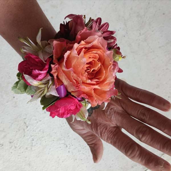 Small wrist corsage with peach and pink flowers