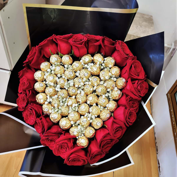 Heart-shaped bouquet of red roses and gold-wrapped chocolates