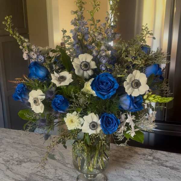Blue and white floral arrangement in a clear glass vase
