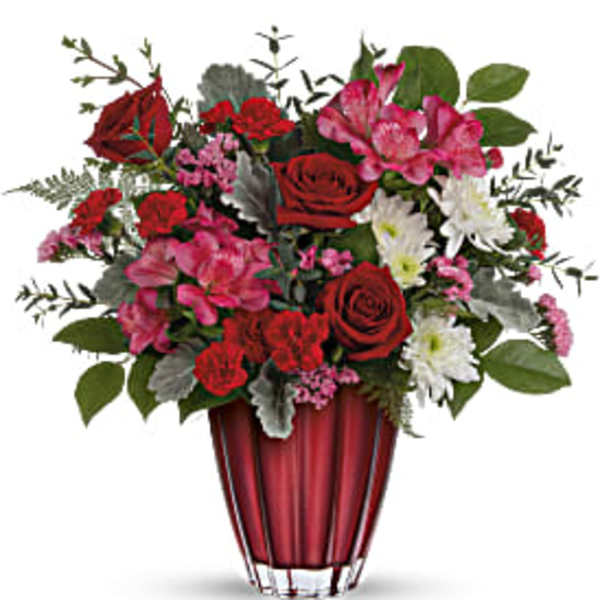 Red and pink mixed flower arrangement in a red vase