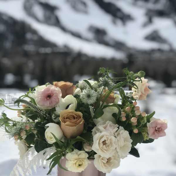 Pastel bouquet of roses and white blooms in a pink vase