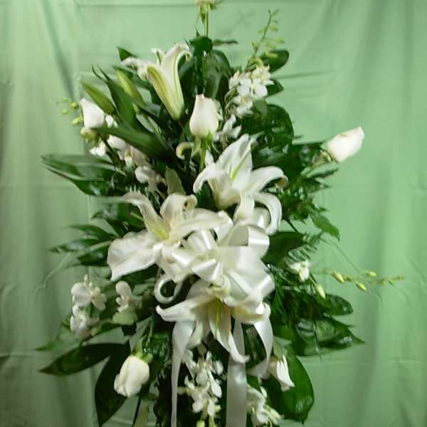 Tall white floral standing spray with lilies and ribbon