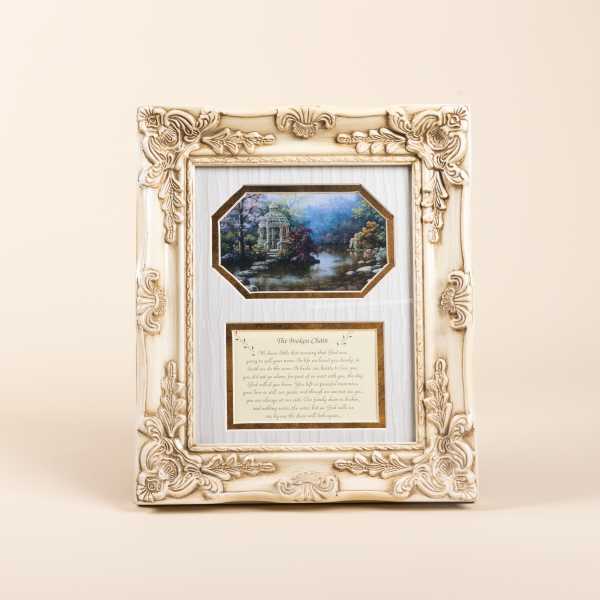 Ornate cream picture frame with a landscape print and memorial text