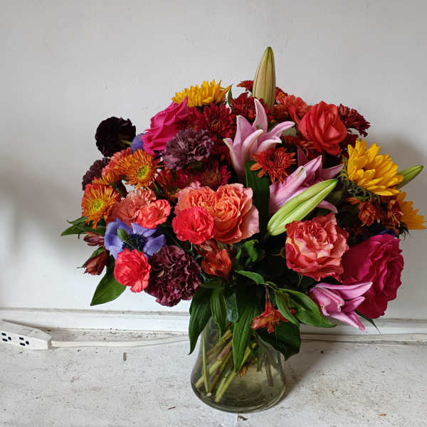 Mixed bouquet of colorful flowers in a glass vase