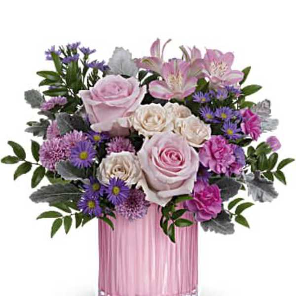 Pink and purple mixed flower arrangement in a pink glass vase