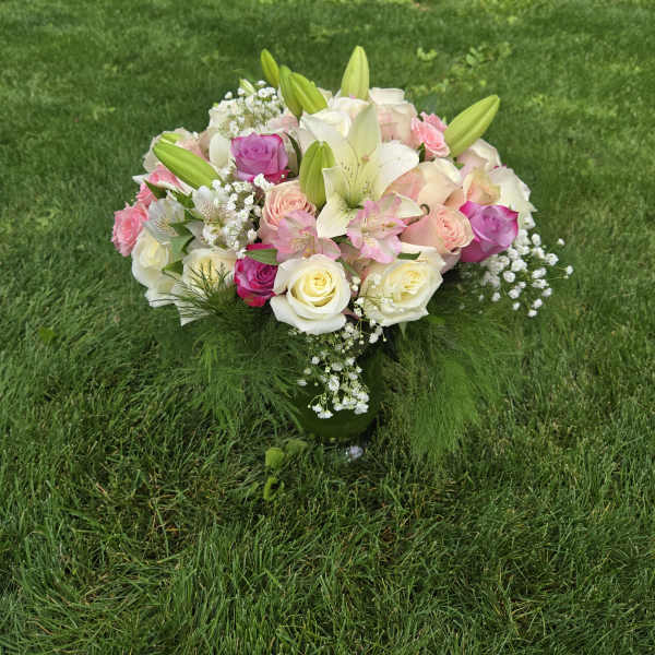 Bouquet of pink and white roses with lilies in a glass vase