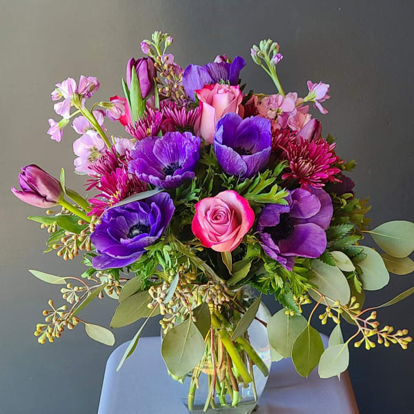 Bouquet of purple and pink flowers in a clear glass vase