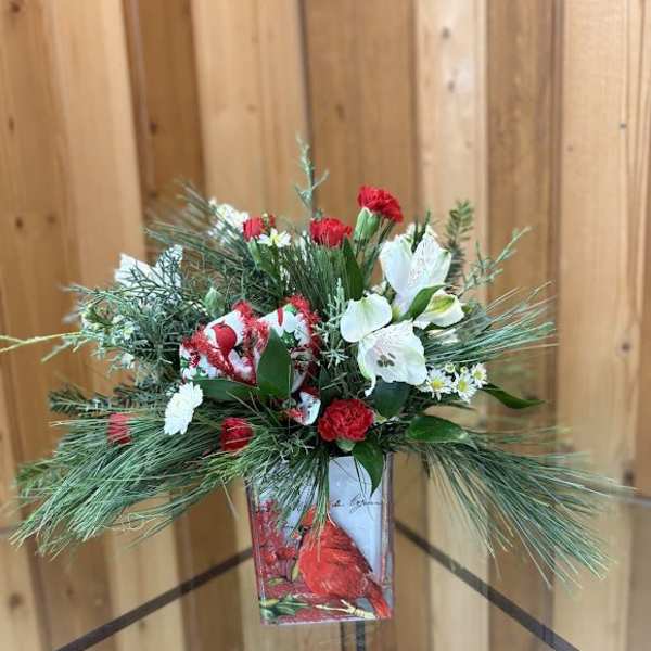 Holiday floral arrangement with red and white flowers in a decorative vase