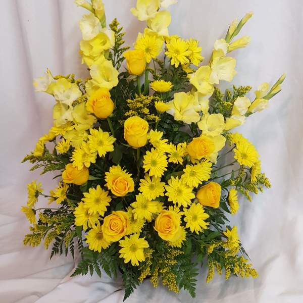Yellow roses and daisies arranged in a tall bouquet