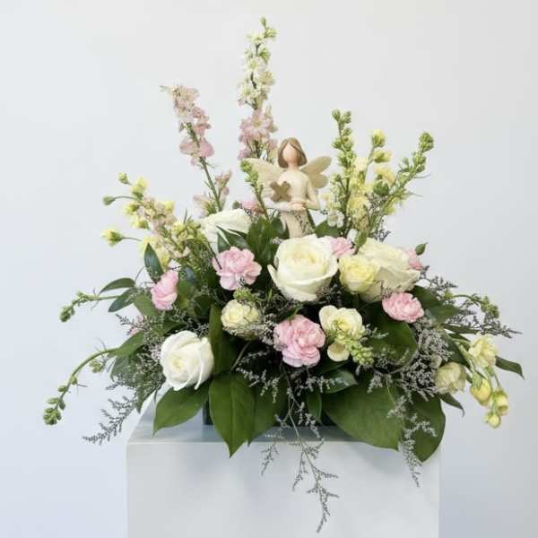 Pastel floral arrangement with roses and carnations on a pedestal