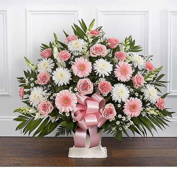 Pink and white floral spray with a pink ribbon on a stand