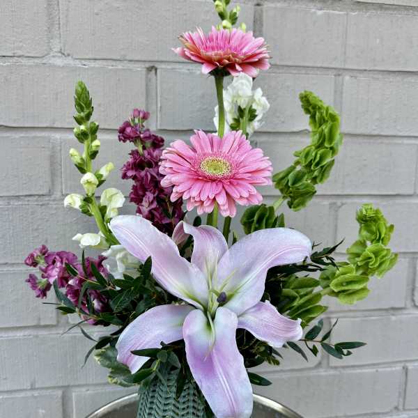 Pink lilies and gerbera daisies in a green vase