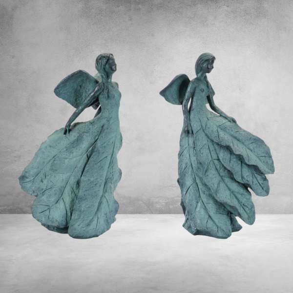 Two teal angel figurines made from leaf-like forms