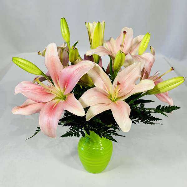 Pink lilies in a bright green vase