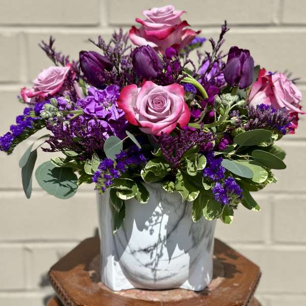 Pink and purple rose bouquet in a gray vase