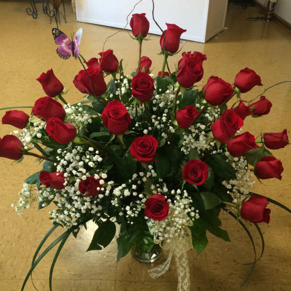 Bouquet of red roses with baby's breath in a glass vase