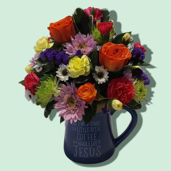 Mixed bouquet in a blue mug with orange, pink, yellow, and purple flowers