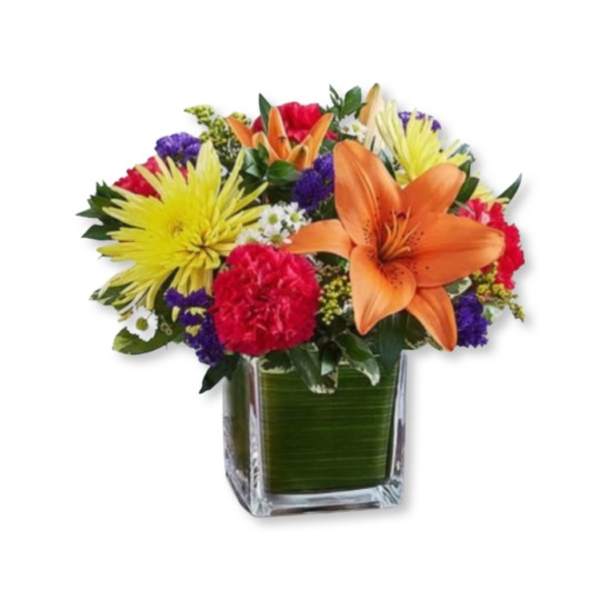 Colorful bouquet of lilies, carnations, and mums in a square glass vase