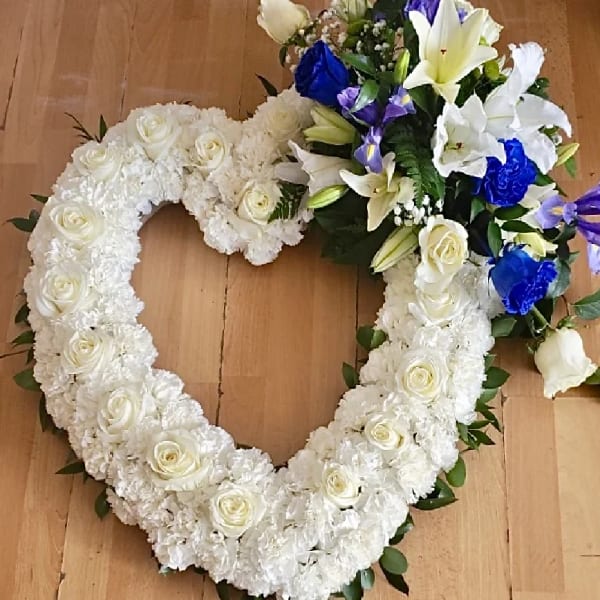Heart-shaped white floral wreath with roses and lilies