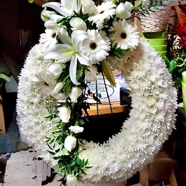 Large white floral wreath with lilies and daisies