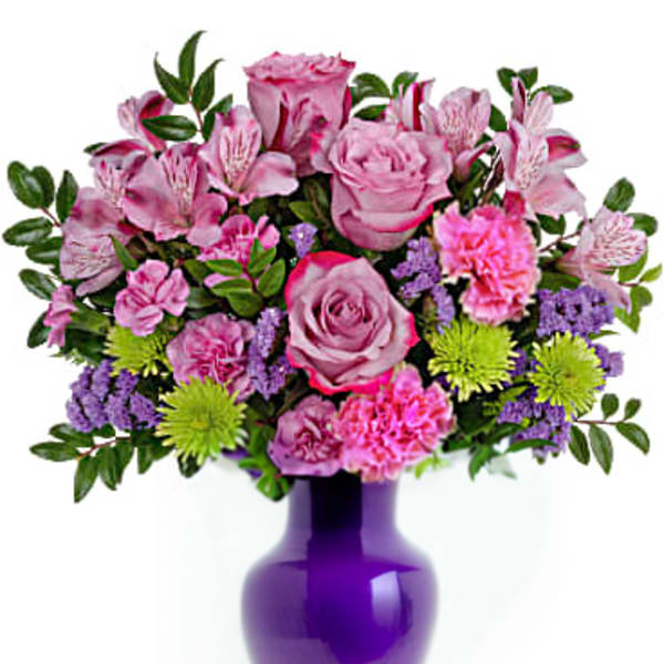 Pink mixed bouquet in a purple glass vase