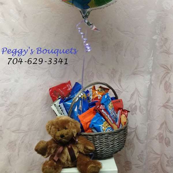 Congrats balloon above a basket of snacks with a teddy bear