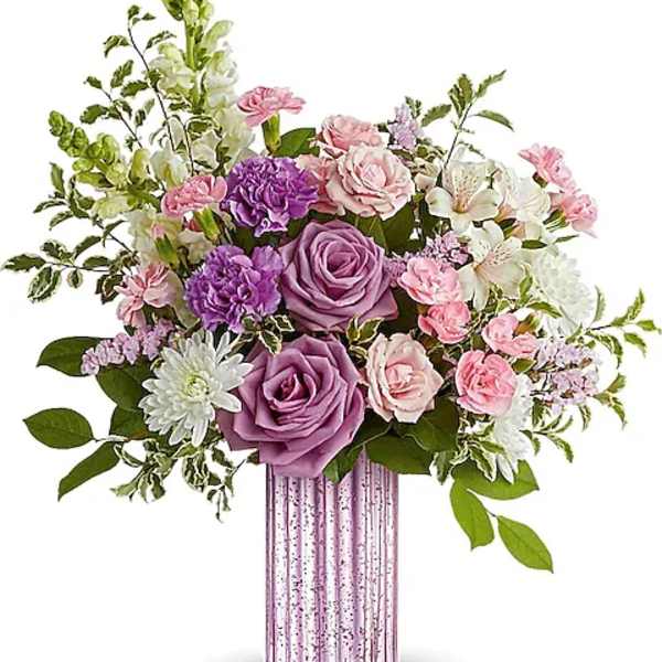 Pink and purple floral arrangement in a ribbed glass vase