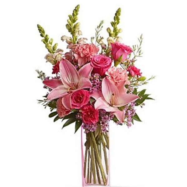 Pink bouquet with lilies and roses in a clear rectangular vase