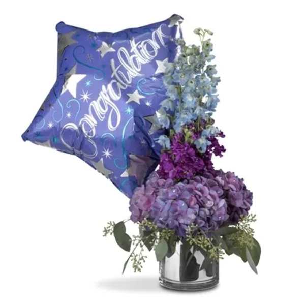 Purple congratulations balloon with a blue floral arrangement in a glass vase