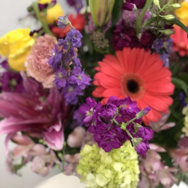 Mixed bouquet with bright gerbera daisies, lilies, and purple blooms