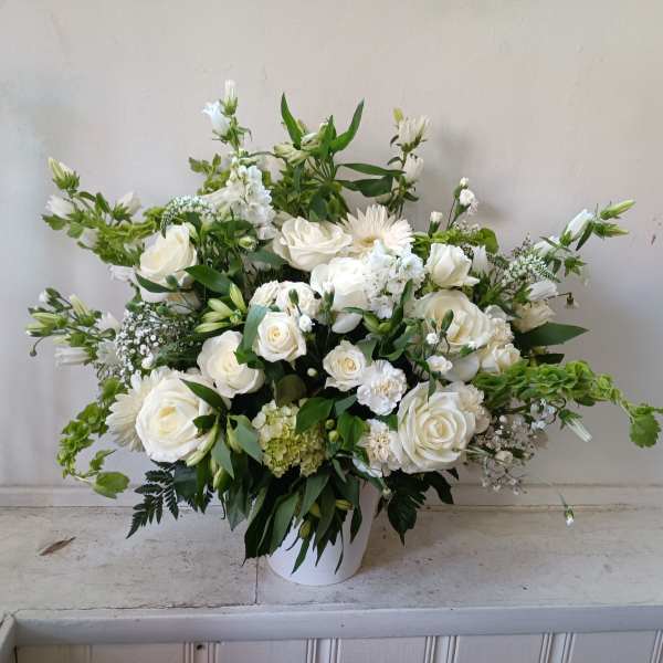 White rose and daisy arrangement in a white vase
