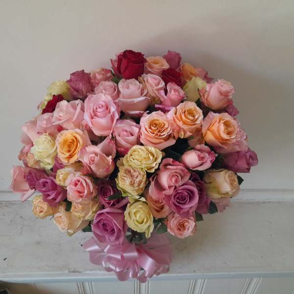 Large bouquet of multicolored roses tied with a pink ribbon