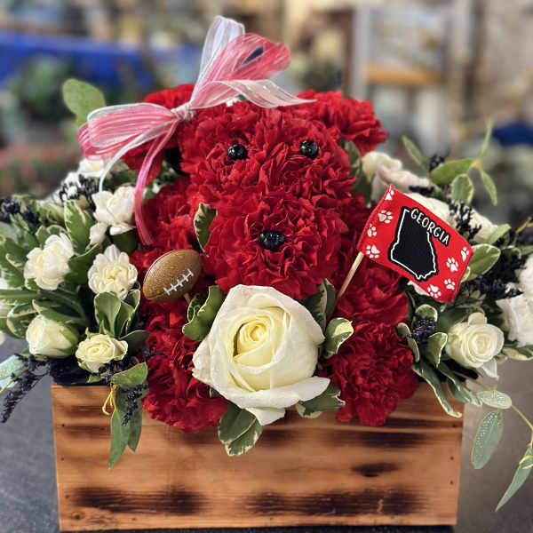 Red carnations and white roses in a wooden box with a ribbon and Georgia flag pick.